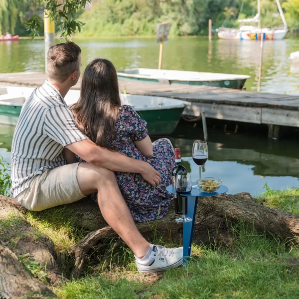 Paar am Seeufer mit Porto Vino Weintisch in Taubenblau, Weinflasche und zwei Gläsern